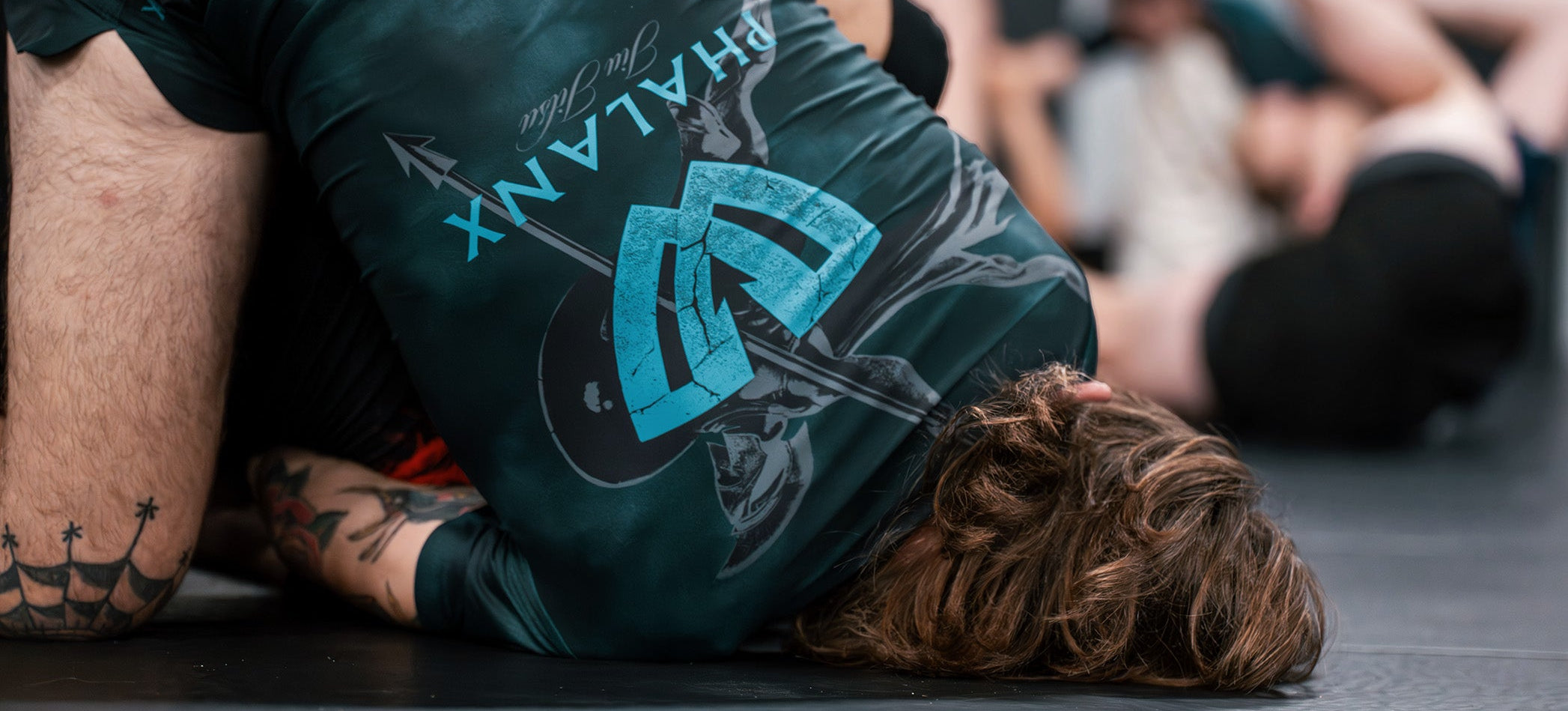 Person wearing a green athletic shirt with "PHALANX" branding on a gym floor.